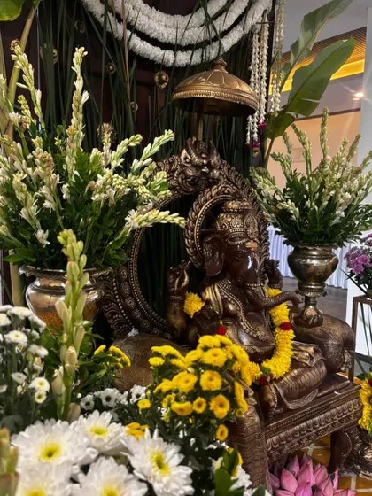A close-up of the beautifully decorated Ganesha idol, showcasing the intricate details and the freshness of the floral arrangements.