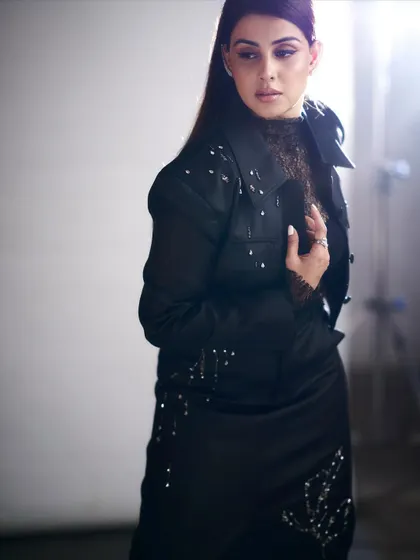 A closer look at the texture and detail. This outfit for Genelia plays with layers, combining a delicate lace top with a structured, embellished jacket.