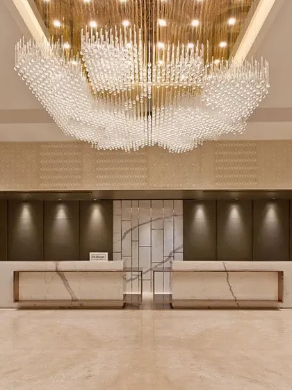 The lobby of a hotel is the first chapter of its story. Here, I designed a grand, welcoming space using a massive, cloud-like chandelier as the focal point. This is supported by precisely aimed downlights that accentuate the marble reception desks, ensuring the space is both awe-inspiring and functional.