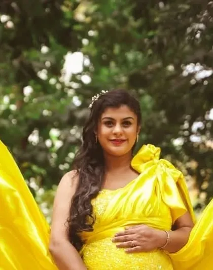 A happy mom-to-be in a bright yellow bodycon dress with a dramatic trail. This rental piece is perfect for clients who want a bold and cheerful maternity shoot.