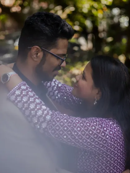 A close-up, intimate portrait of the couple looking into each other's eyes, framed by a soft foreground for a dreamy effect.