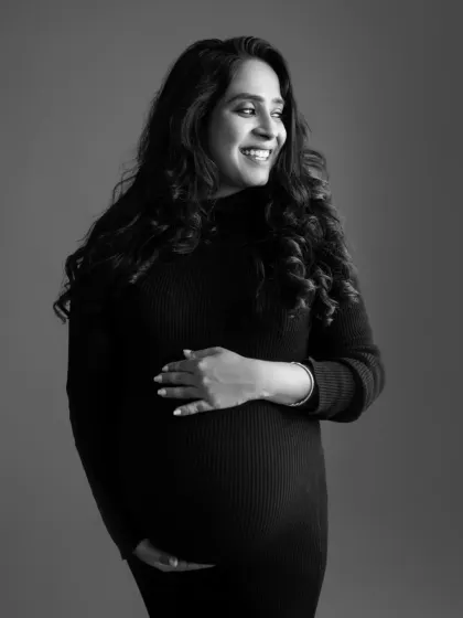 A classic black and white maternity portrait. The soft lighting and her gentle smile create a feeling of warmth and serenity. This timeless style will never fade.