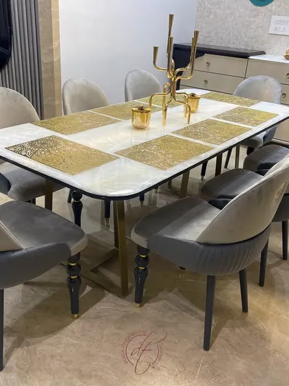 A close-up of the elegant dining table and chairs. The two-tone velvet upholstery on the chairs and the unique design of the table legs showcase our attention to custom furniture details.