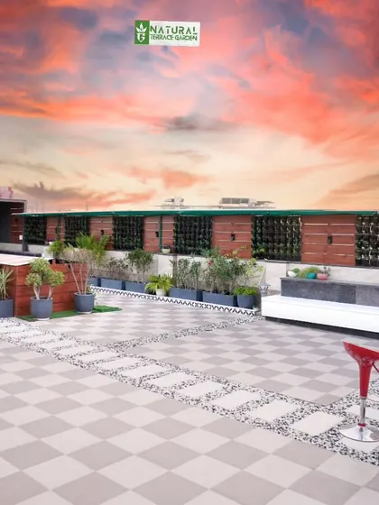 A wide daytime shot of the Palam Vihar terrace, showing the expansive checkered tile patio and a long vertical garden wall.