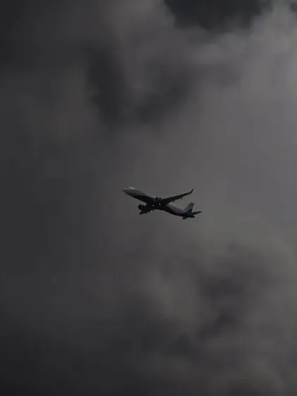 An airplane flying through dark, stormy clouds. This moody shot creates a sense of drama and journey.