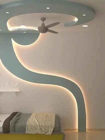 This bedroom features a unique false ceiling and wall design with a flowing, curved shape highlighted by cove lighting. It adds a dynamic and artistic element to the room.