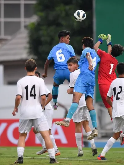 A goalkeeper and defenders from the Indian U17 team rise to challenge for the ball. This highlights the importance of vertical jump training and aerial dominance, key components of our performance program.