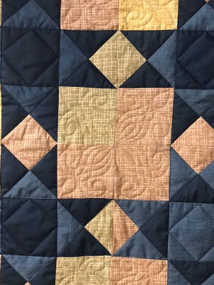 Detail of the piecing and quilting on the Sawtooth Star suit quilt.