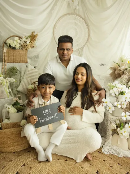 "Big Brother!" This proud older sibling announces his new role in a fun and heartwarming family portrait. It's a perfect way to include the whole family in the maternity journey.