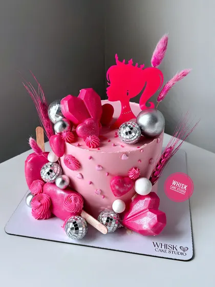 A client asked for a pink Barbie cake, and we delivered this masterpiece. This cake is an explosion of pink, with geometric hearts, disco balls, and a custom topper.