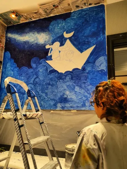 A view from behind as I add the final touches to the large wall mural. This piece was created to inspire wonder and sweet dreams.