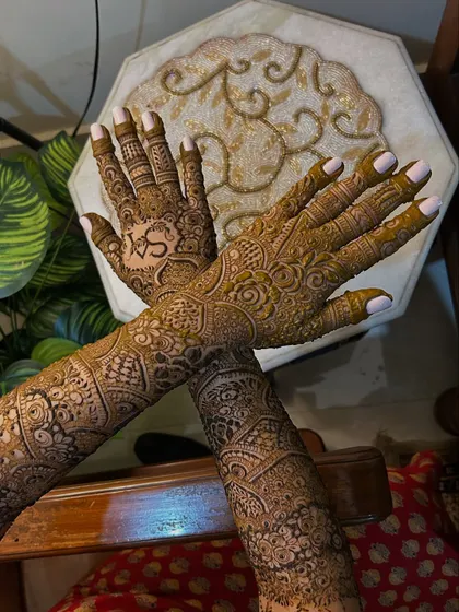 The crossed-hands pose shows how the intricate patterns flow seamlessly from the palms to the arms. This full-coverage look is a favorite among my brides.