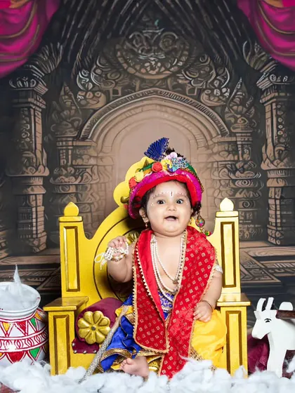 This little Krishna is sitting on a grand throne, looking every bit the part of a divine king.