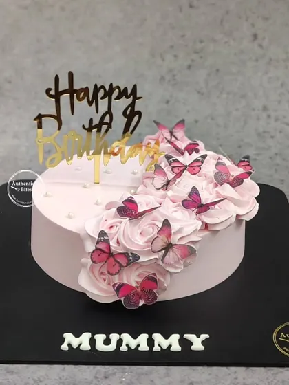 A beautiful butterfly cake for a mother's birthday. A cascade of pink buttercream roses is adorned with a flight of delicate pink butterflies.