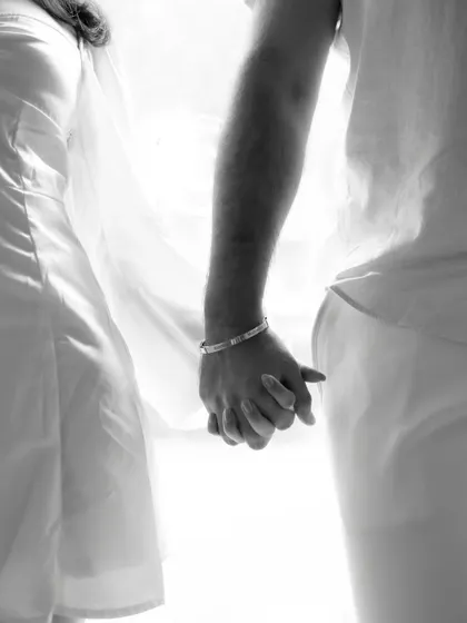 A simple, intimate black and white shot of the couple holding hands. This photo focuses on the symbol of their connection and the promise they've made to each other.