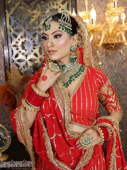 The bride adjusting her jewelry, giving a clear view of the intricate necklace and earrings.