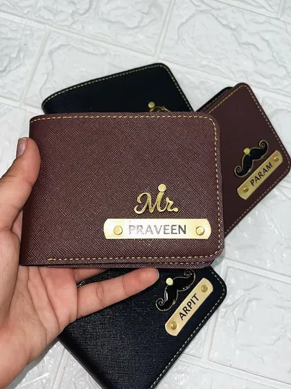 This brown personalized wallet features the "Mr." charm and the name "Praveen." The combination of the gold nameplate and charm against the rich brown color creates a classic, sophisticated look.