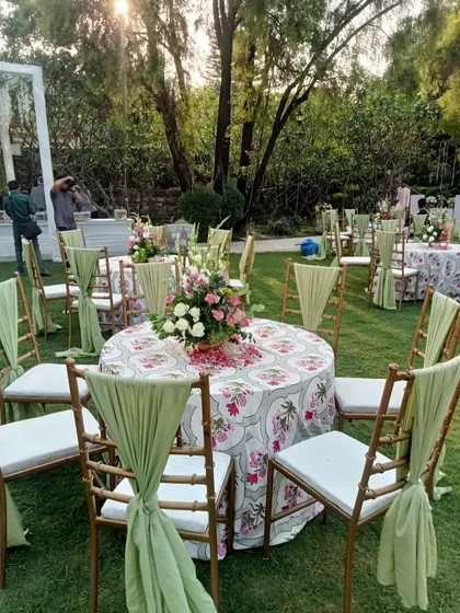 A closer look at the guest seating, with round tables, beautiful floral centerpieces, and elegantly draped chairs.
