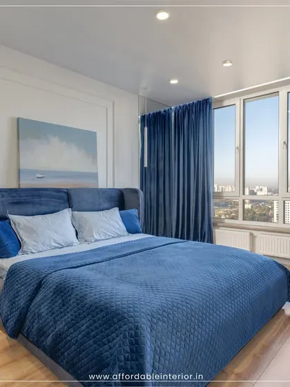 This modern bedroom features a deep blue color scheme, a comfortable upholstered bed, and large windows that offer a stunning city view.