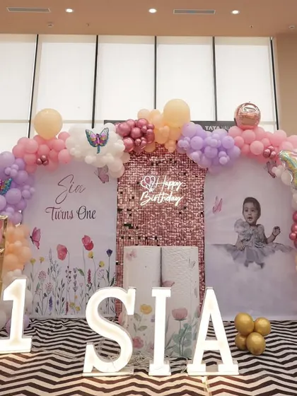 A frontal view of Sia's birthday stage, highlighting the marquee letters, light-up number '1', and the custom photo backdrop.