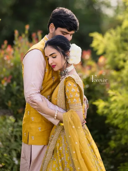 A romantic embrace during a pre-wedding shoot. The bride's makeup is soft and natural, with a beautiful white flower in her hair.