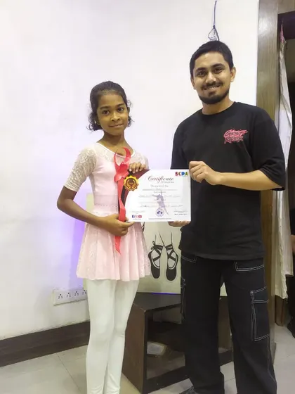 A young ballerina receiving her certificate. I offer specialized courses and certification in specific dance styles like ballet.