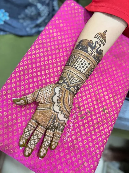 A side view of a bridal arm design, highlighting the band of royal elephants and the detailed check and floral patterns.
