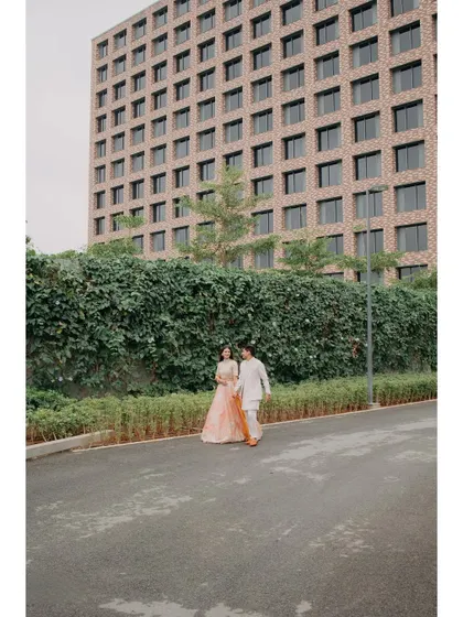 Abhishek and Raashi walk hand-in-hand during their Haldi event. The modern architecture of the Hilton Bangalore provides a unique backdrop for their traditional celebration.