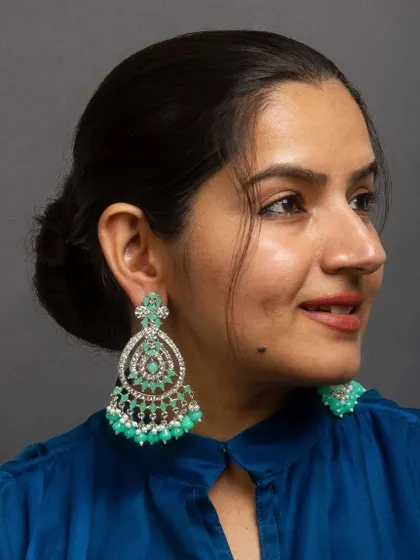 Aqua green hues for a refreshing look. These silver-toned chandelier earrings are set with American diamonds and finished with beautiful aqua green beads.