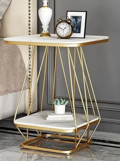 A modern geometric side table, featuring a wireframe base with a gold finish and two marble surfaces for displaying decor.