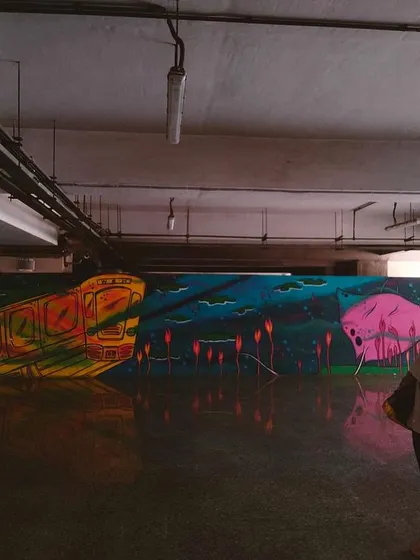 Me looking at another one of my murals in the metro station, a surreal piece featuring a train and a pink moon.