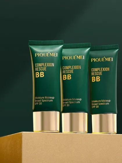 A clean and minimalist arrangement of PiqueMei's BB cream. The simple composition on a textured block against a solid background emphasizes the product's sleek packaging and high-end feel.