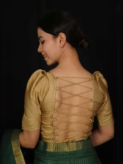 A golden blouse with a stunning corset-style tie-up back. The puffed sleeves add a romantic touch to this unique design.