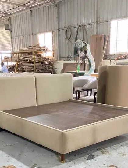 Minimalist chic meets maximum comfort. A custom-made bed with a simple, clean-lined upholstered frame and headboard, seen here in our factory before being shipped.
