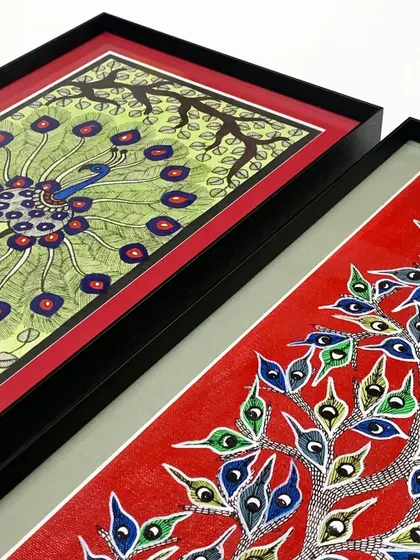 A detailed look at the layers of framing for these peacock artworks, showing the black metal frame, the red inner mat, and the gray outer mat working together to create depth.