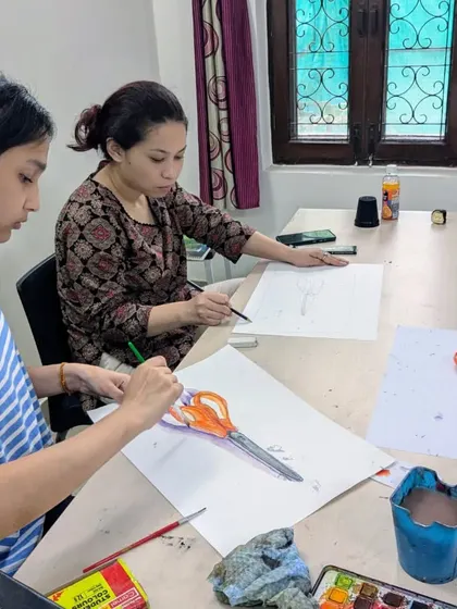 Students working diligently on their object studies of scissors. This side-by-side work allows for peer learning and individual focus within a group setting.
