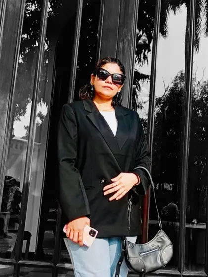A closer look at the details of a classic outfit. The structure of the double-breasted blazer, paired with modern sunglasses and a simple handbag, shows how accessories complete a minimal look.