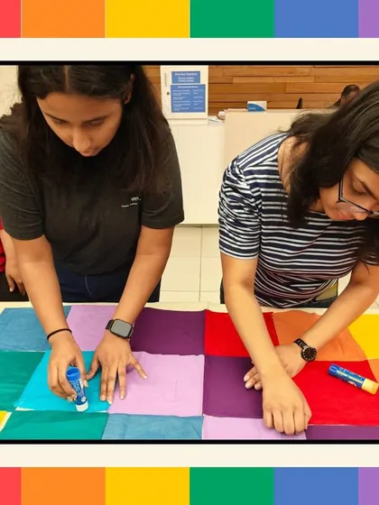 Employees carefully place and glue fabric squares during our Pride quilt making workshop. This simple, accessible activity allows everyone to contribute to a larger, meaningful project.