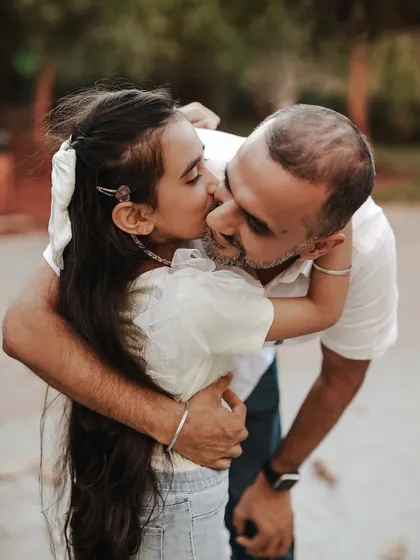 A sweet kiss from daughter to dad. Outdoor sessions allow for so much movement and genuine interaction, resulting in photos filled with authentic love and connection.