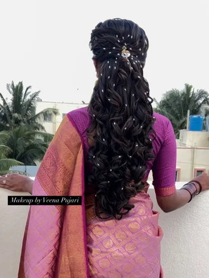 A dreamy and romantic hairstyle for a reception or engagement. The long, flowing curls are adorned with delicate pearl-like beads, creating a beautiful, ethereal effect.
