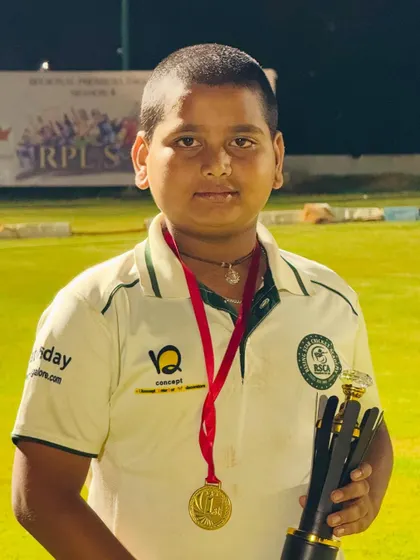 A junior player with his trophy and medal, looking proud of his achievement.