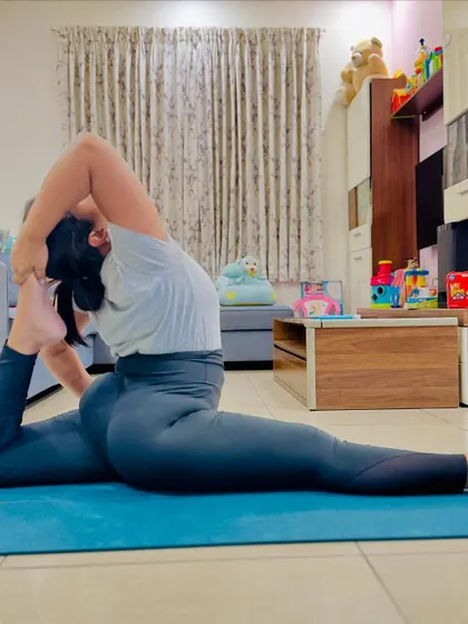A student achieving the advanced variation of Hanumanasana, touching her foot to her head. This is the result of incredible effort and dedication to her practice.