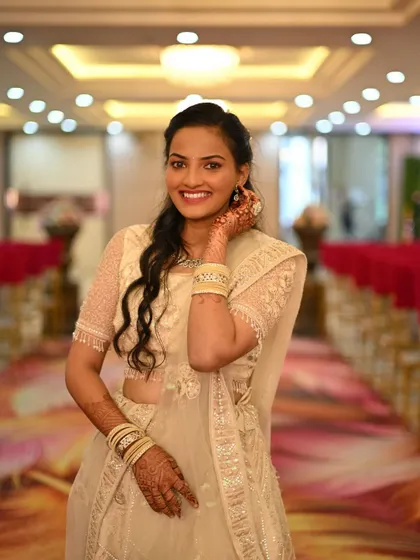 A happy client looking stunning in an ivory lehenga with delicate threadwork. This is a great choice for engagement parties or post-wedding events.