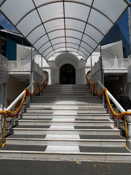 The entrance of a Gurudwara or temple decorated simply with marigold garlands for a wedding ceremony.
