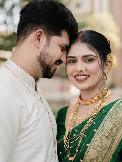 An intimate close-up capturing the bride's radiant smile and the couple's gentle affection, with a focus on her stunning traditional gold jewelry.