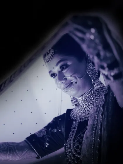 An artistic, low-light portrait of a bride under her veil, creating a mysterious and beautiful mood.