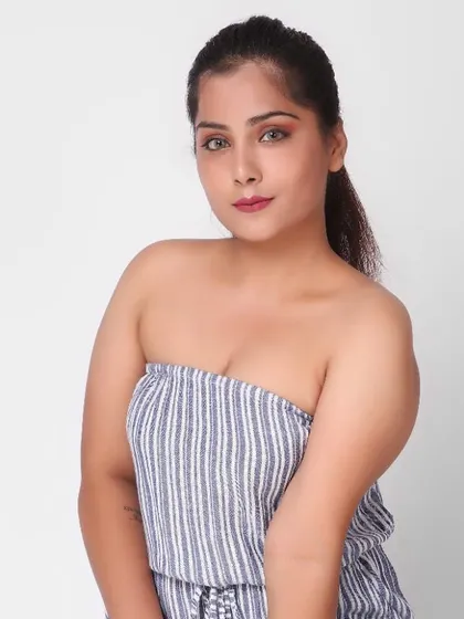 A clean and simple bust-up shot is essential for any e-commerce shoot. This image of a plus-size model in a striped jumpsuit provides a clear look at the garment's neckline and the model's commercial appeal.