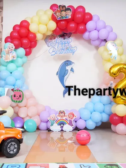 A close-up of the Cocomelon ring decoration, showing the character cutouts and the number '2' foil balloon.