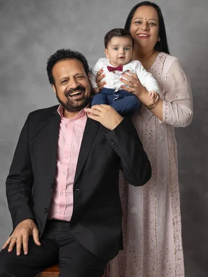A playful and joyous portrait of grandparents with their grandbaby. The grandfather's happy expression shows the immense happiness a new child brings to the family.