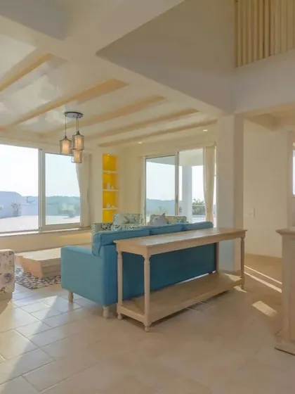 The living room in the Goa home is bathed in natural light. The design uses a neutral base with infusions of yellow and blue, while light-toned furniture maintains an airy, relaxed aesthetic perfect for a holiday retreat.
